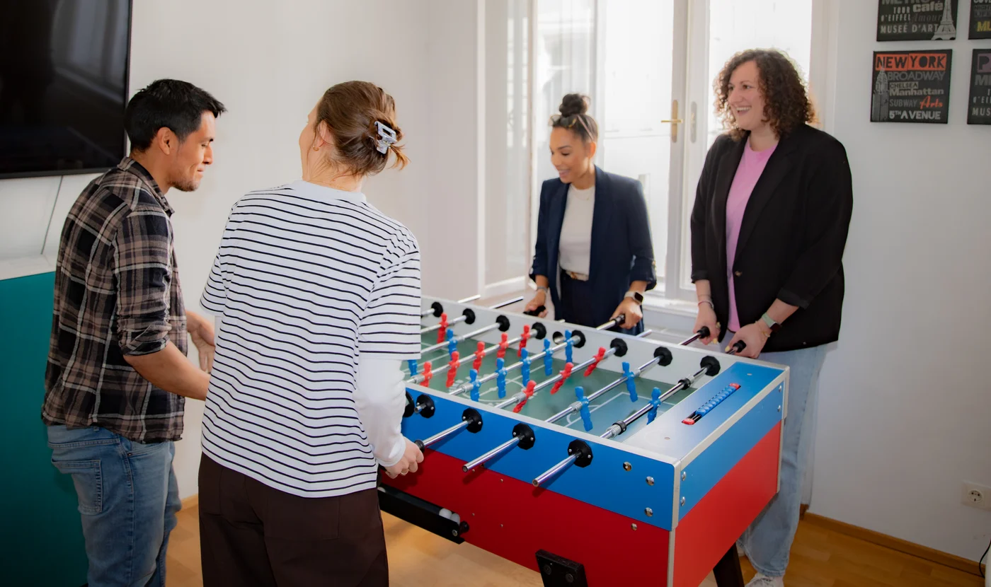 The Improove team playing table football at the Vienna office